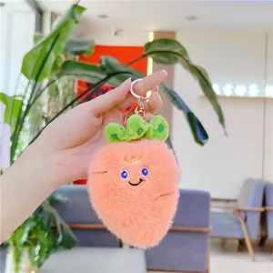 Dettaglio di un portachiavi a forma di carota in peluche rosa con ricamo e gancio