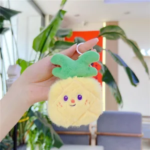 Dettaglio del portachiavi peluche a forma di ananas giallo con ricamo dolce e gancio