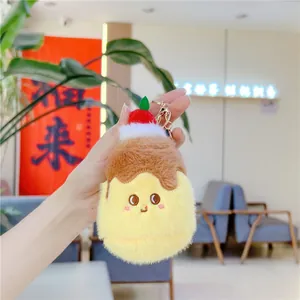 Close-up of a cute plush pudding keychain with cartoon embroidery and a gold ring
