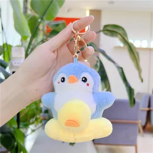 Detalle del llavero de pingüino de peluche con base de anillo amarillo y gancho dorado