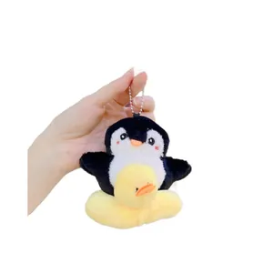Llavero de pingüino de peluche con un pequeño patito amarillo y cadena de bolas de metal