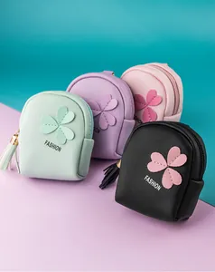 Close-up of mini PU leather coin purses with clover applique and tassel details