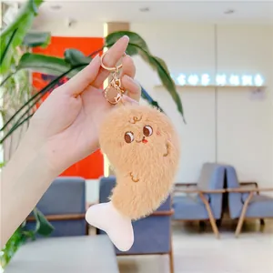 Gros plan d'un porte-clés en peluche cuisse de poulet avec broderie et fermoir doré brillant