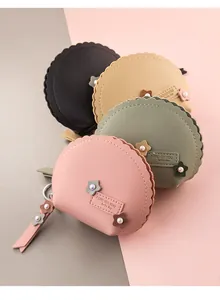 Detalle de monederos de cuero PU festoneados con flores de perlas y correa de muñeca