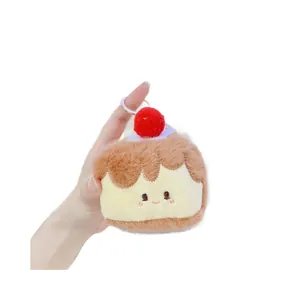 Porte-clés gâteau en peluche mignon avec cerise et visage brodé tenu dans la main