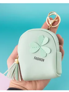 Macro detail of mint green mini backpack coin purse with gold hardware and tassel