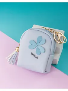 Close-up of light blue leather mini coin purse with clover patch and white tassel detail