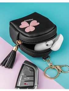 Detail of mini black PU leather coin purse with pink flower applique and tassel keychain