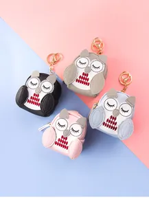 Detail of owl mini coin purses in four colors with gold metal hooks and zip closure