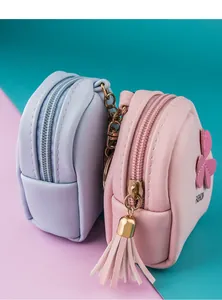 Close-up of mini PU leather coin purses in pastel blue and pink with floral tassels