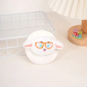 Detail van zachte pluche portemonnee met schattig geborduurd schaap en oranje bril