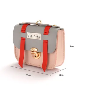 Detailed view of mini crossbody bag with pink and grey contrast leather and metal lock