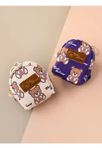 Detail of mini bear coin purses in cream and purple with pearl zipper and gold hooks