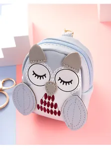 Detail of owl coin purse keychain with blue leather, embroidery and gold hook