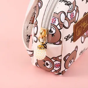 Cute cartoon bear coin purse with pearl pendant and golden zipper on pink background