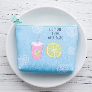 Light blue cartoon coin purse with cute lemon illustration and zipper on a white plate
