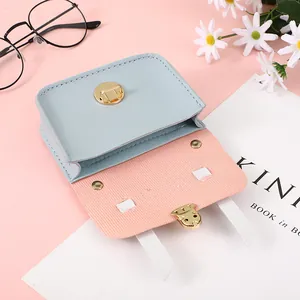 Detail view of mini contrast crossbody bag featuring light blue faux leather and gold clasp