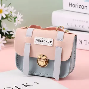 Detailed close-up of pink and blue mini purse with delicate label and gold lock