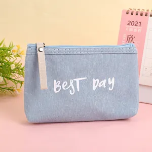 Detail of light blue canvas pouch with white best day text and silver rivet decoration