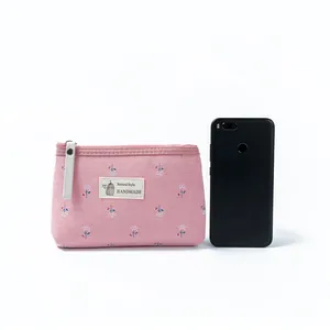 Trousse de maquillage rose fleurie en toile avec fermeture éclair et comparatif de taille