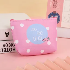 Close-up of pink polka dot coin purse featuring lucky slogan and cute carrot motif