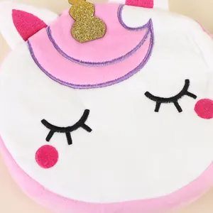 Close-up of unicorn plush bag with embroidered eyes, golden horn, and soft pink fur details