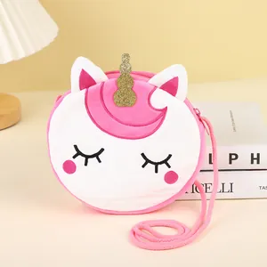 Detailed view of plush unicorn bag featuring golden horn and embroidery on pink surface