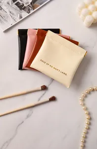 Close-up of four colorful leather coin pouches with metal squeeze top on marble background