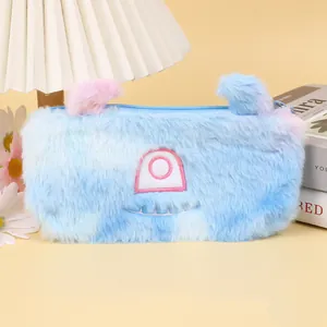 Détail de la trousse monstre bleue en peluche avec de grands yeux brodés