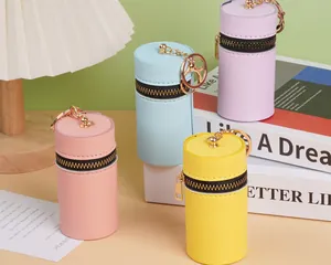 Détails macro de mini porte-monnaie cylindriques colorés avec ferrures dorées et zip
