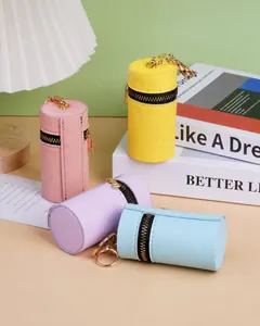Détail de mini porte-monnaie cylindriques avec porte-clés dorés et cuir PU à motif croisé