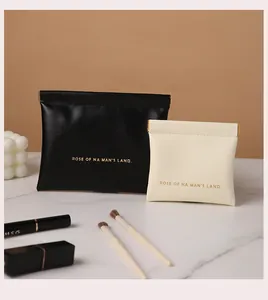 Detail of portable PU leather pouches in black and cream for lipstick and jewelry