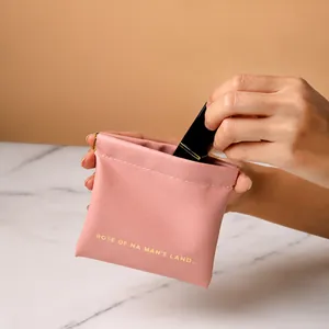 Pink PU leather lipstick pouch featuring a squeeze-to-open design with yellow text