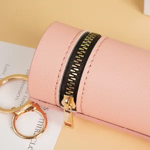Petit porte-monnaie cylindrique rose en cuir PU avec fermeture éclair dorée et texture