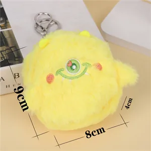 Detail showing plush yellow monster coin purse with size dimensions and metal keyring