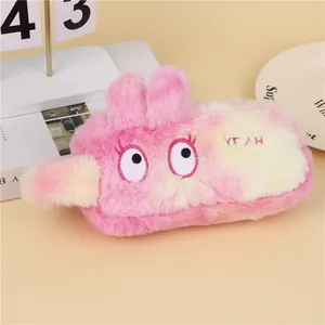Detailed macro view of soft pink and yellow plush stationery pouch with YEAH embroidery