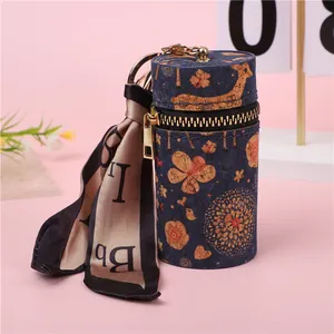 Detalle de mini bolso cilíndrico con textura de corcho, estampado de ciervo y pañuelo