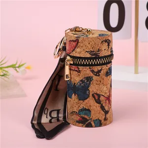 Detalle del monedero cilíndrico de corcho con mariposas de colores y cinta de seda suave