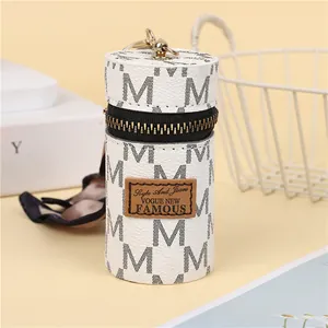 Detail of vintage patterned cylinder coin purse with gold zipper and swivel hook hanging