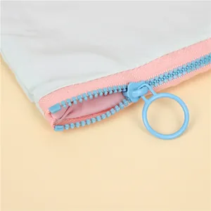 Macro detail of macaron blue waterproof makeup bag with pink zipper and round ring puller