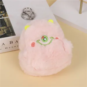 Close-up of fluffy pink monster plush coin purse with embroidery and silver metal keychain
