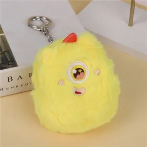 Close-up of yellow plush monster coin purse with soft texture and metal keychain ring