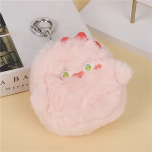 Close-up of pink fluffy monster plush keychain with soft fur and metal lobster clasp