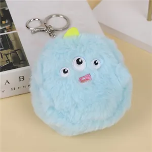 Close-up of blue plush monster coin purse with three eyes embroidery and metal keychain