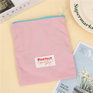 Pink nylon travel makeup bag with blue zipper and decorative 'PERFECT' label text