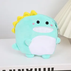 Detail of mint green plush dinosaur coin purse with yellow fins and silver metal chain