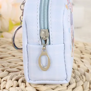 Detail of light blue leather mini pouch with textured grid pattern and metal zipper