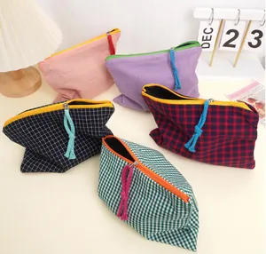 Detailed view of checkered cosmetic bags with colorful zipper pulls and woven textures