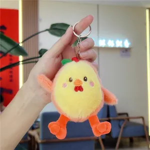 Vue à la main du porte-clés poussin en peluche jaune avec anneau métallique
