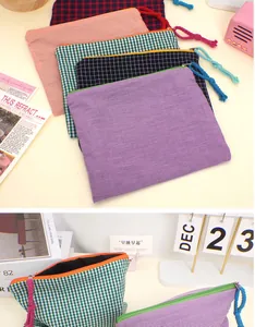Close-up of assorted plaid cosmetic bags with cotton rope zippers and various color patterns